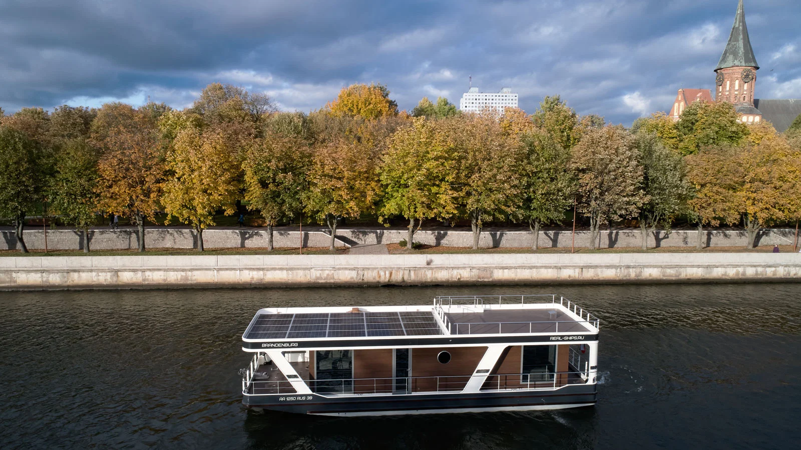 A houseboat build by "Ushakov shipyards" passing by Kant Island in Kaliningrad